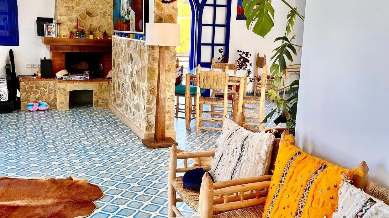 Salon chaleureux avec cheminée et tables du restaurant à Dmina House