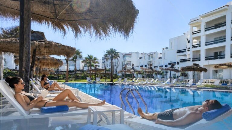 Grande piscine extérieure et espaces de repos au Playa Del Pacha Suites, hôtel en front de mer